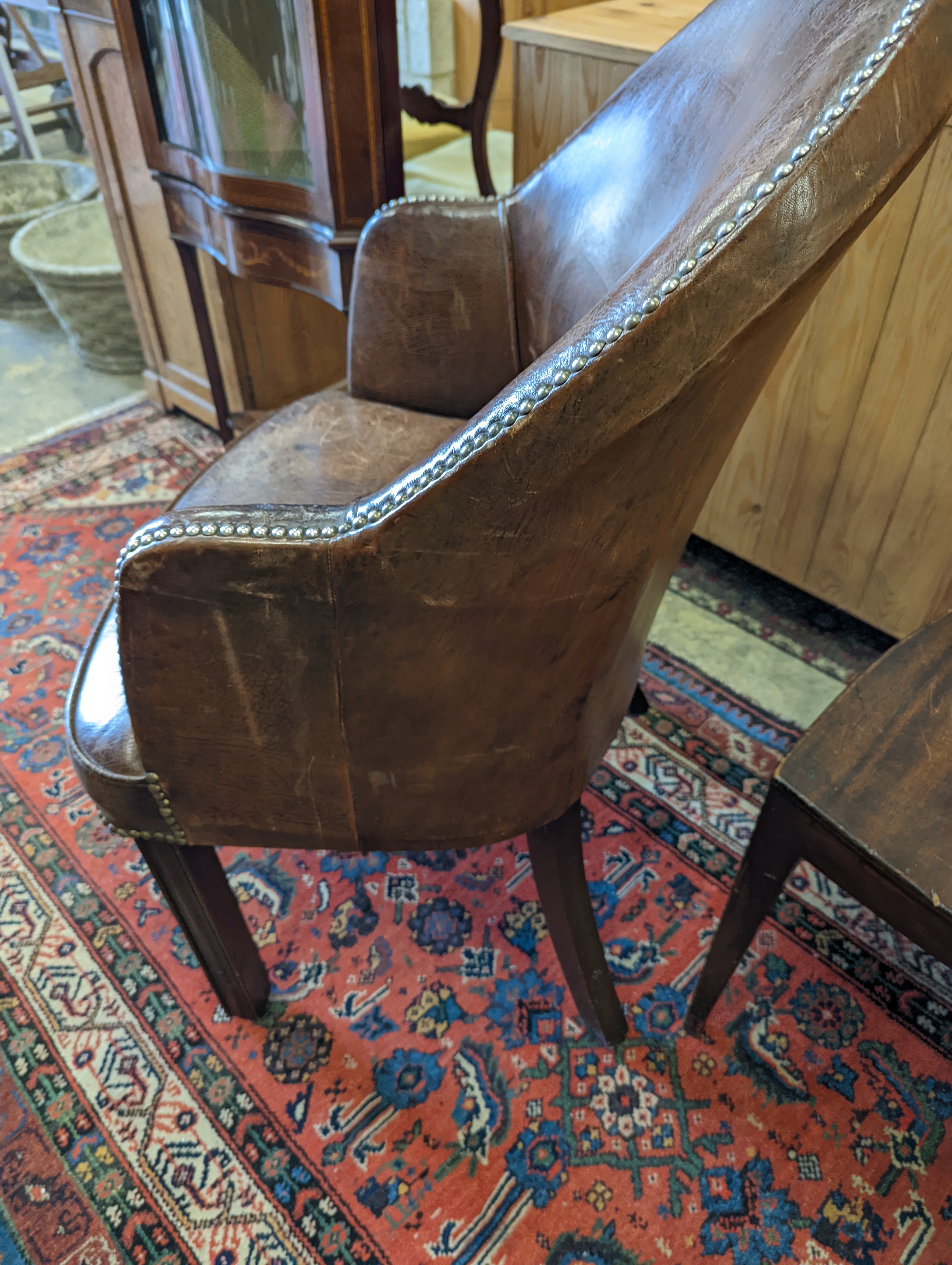 A brown leather upholstered desk chair, a mahogany hall chair and two upholstered armchairs